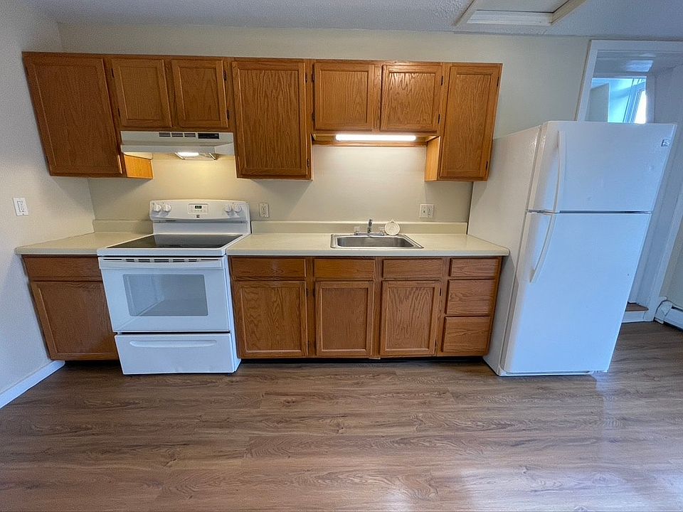 Kitchen cabinets with stove, fan, sink and fridge (Note: This photo is from the apartment next to it)