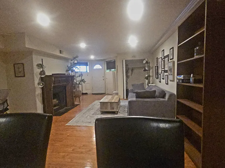 View of Front Room and Front Door. Note nice closet (DOR OPEN) and fireplace. tHe two black objects nearest the camera are thebacks of 2 chairs at the ample kitchen counter.