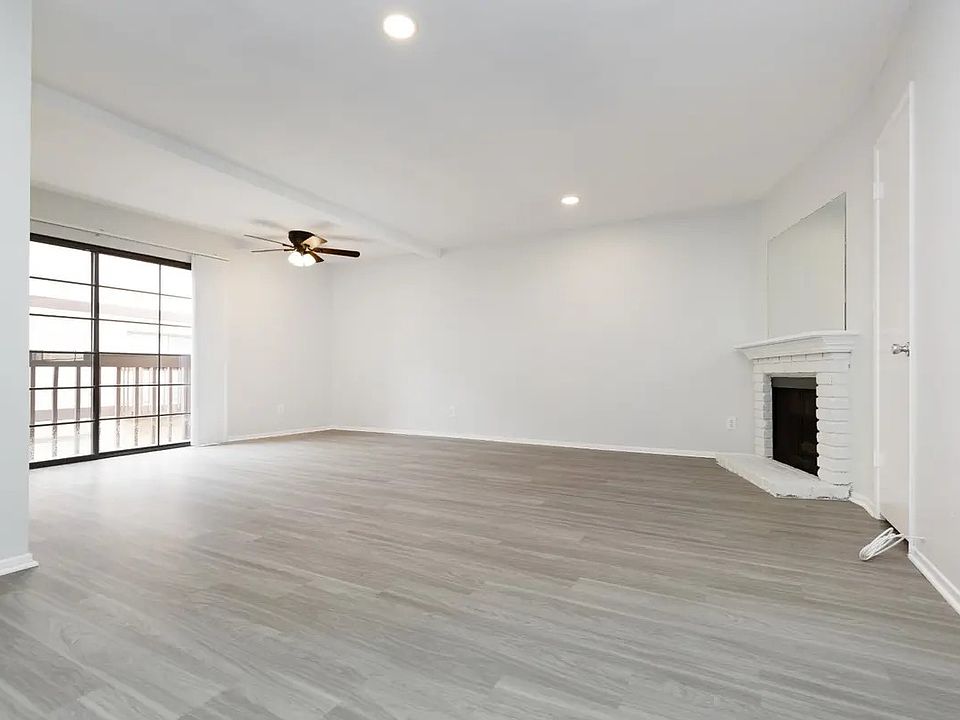 downstairs view of living area, dining area, decorative fireplace and balcony. units vary