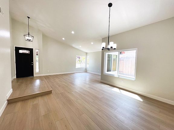 NEW, SPACIOUS living and dining rooms with large windows, modern light fixtures, and luxury vinyl flooring throughout!