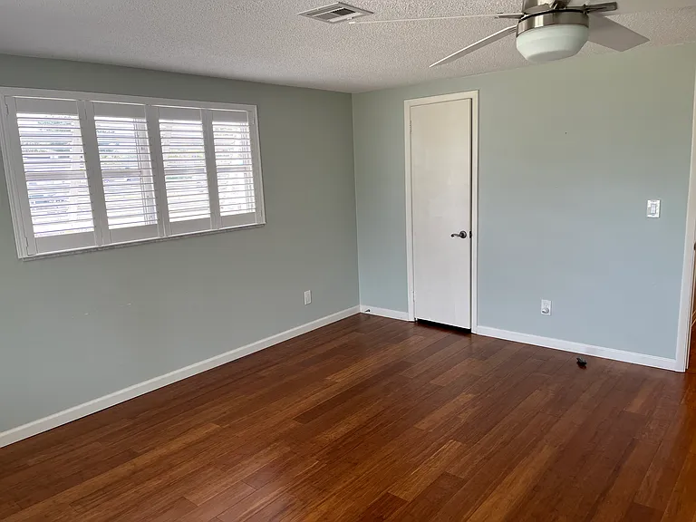 Large bedroom with plantation shutters and walk in closet
