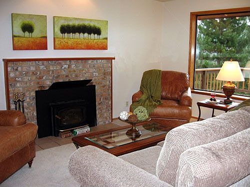 Living room sitting area around fireplace. Huge window to overlook view