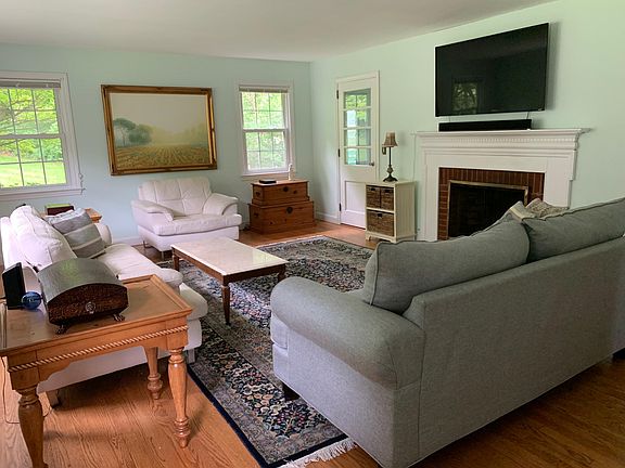 Living Room with Wood-Burning Fireplace. Hardwood Floors on Main Level. Door to Sun Porch.