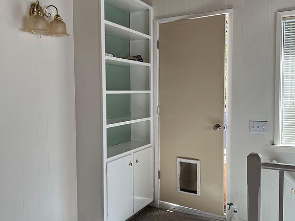 Bookcase, door to small deck over breezeway between upper apartment and house