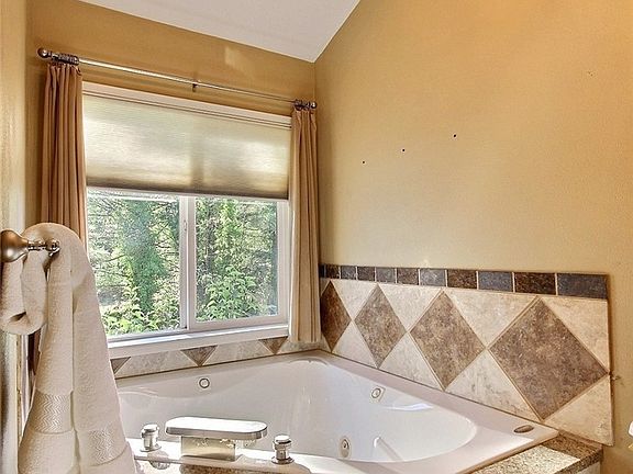 Imagine soaking away in this lovely corner Jacuzzi tub.