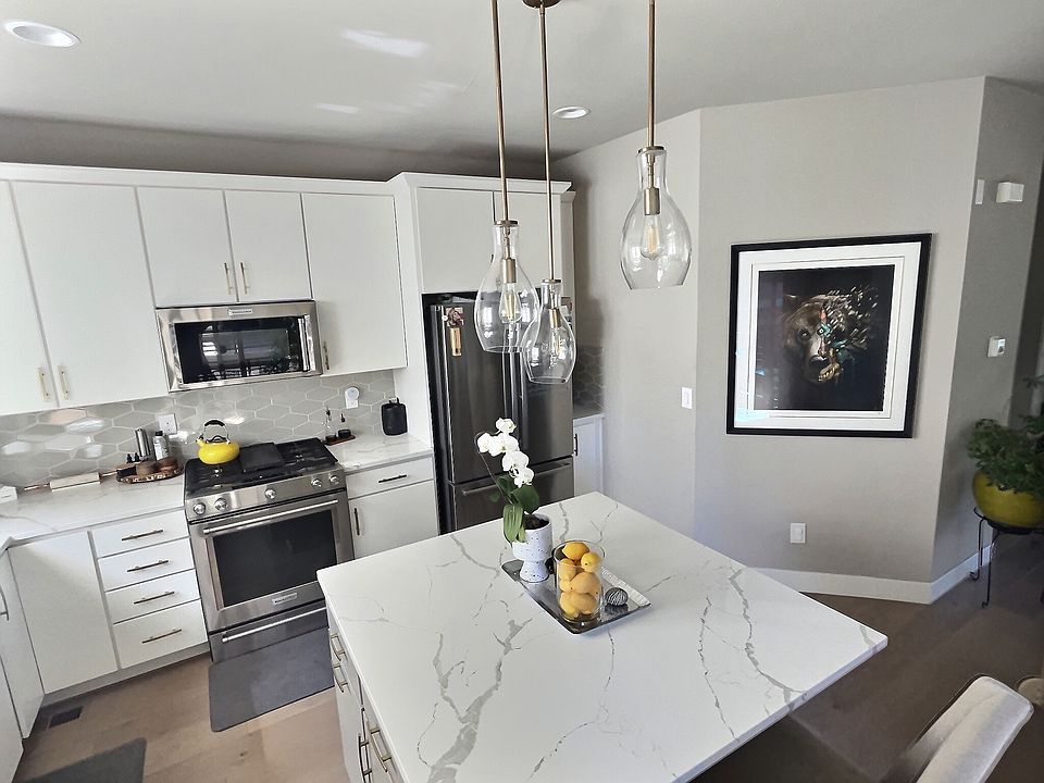 Enjoy a chef's dream kitchen with quartz countertops, a large island, and stainless steel appliances, flowing seamlessly into the dining and living areas.