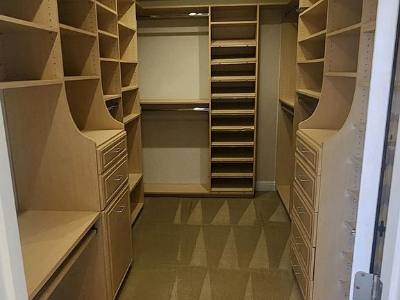 Large walk with custom built in cabinet and sky light in primary bedroom.