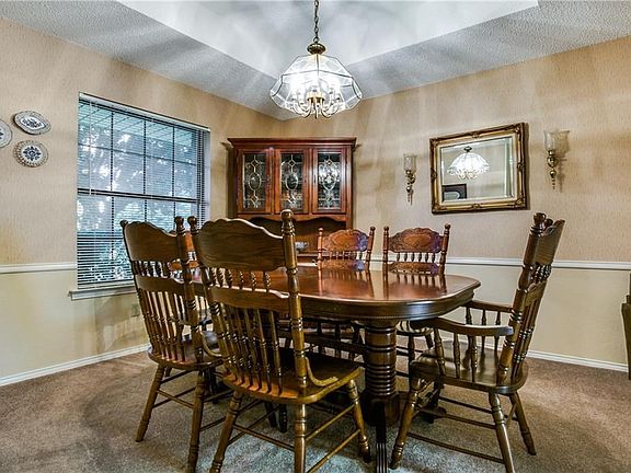 Formal dining room features a tiered ceiling and chair rail molding...this room could make a great home office too!
