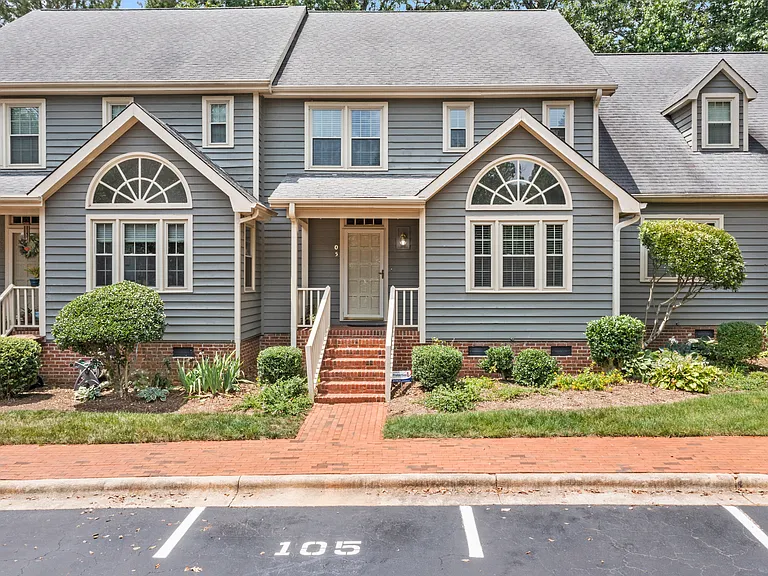 Welcome to 105 Pebble Loch, a charming townhome with classic curb appeal and a brick-lined entry.