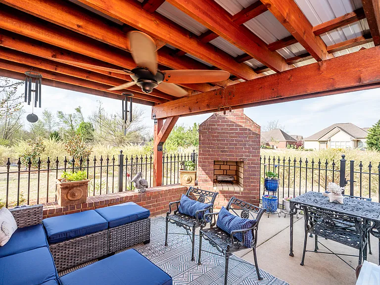 Patio with wood burning fireplace and covered pergola and fenced.