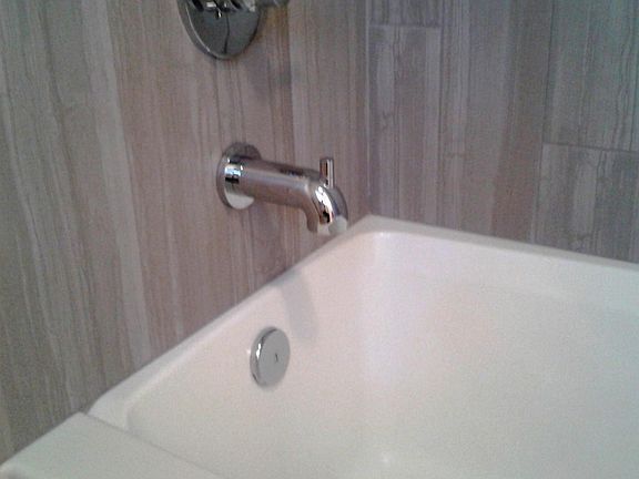 Porcelain large tiled tub/shower, tile to ceiling.