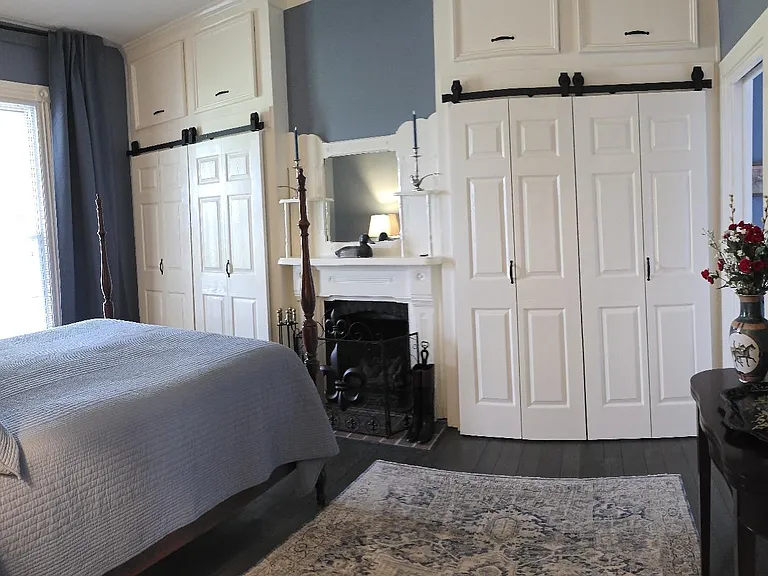 Panoramic view of primary bedroom from hallway: ample storage. Queen sized vintage four poster bed. Seasonal decor included in furnishings - July 4th, Fall Keeneland Racing Season, Thanksgiving/Christmas, Spring - Keeneland/Derby Racing Season.
