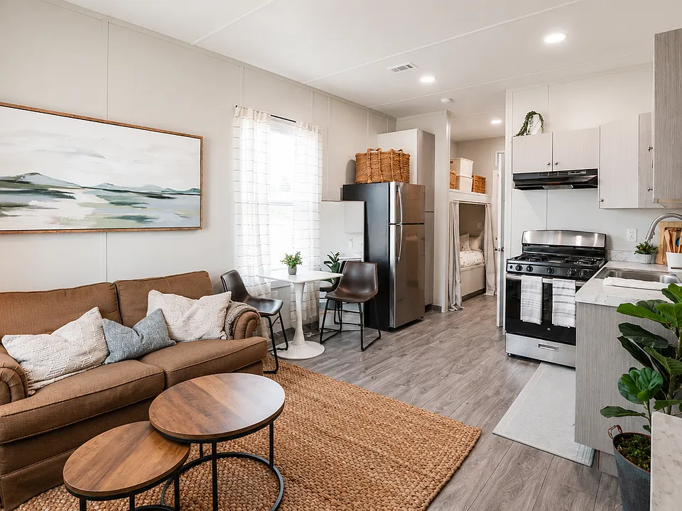 Open living area. Home comes with essential furnishings: bed, futon, refrigerator, and stove.