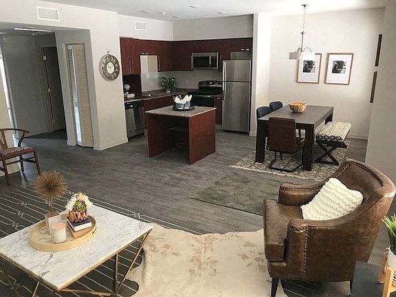 Living room view of dining area and kitchen at City Plaza Apartments in Escondido, California.