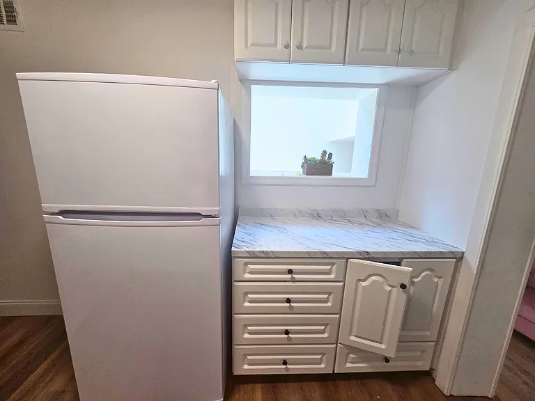 Full-size fridge and spacious cabinets for convenient food storage.