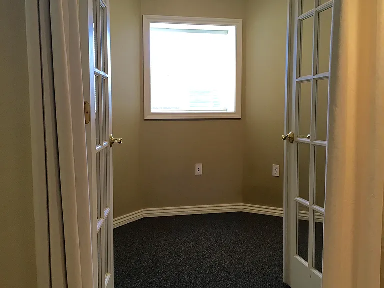 French doors to south bedroom. Bedroom overlooks the patio and window gardens.