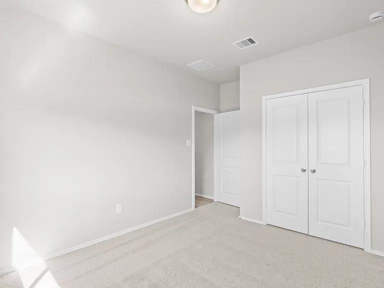 Well-sized secondary bedroom with plush carpet, double door closet, and natural light.