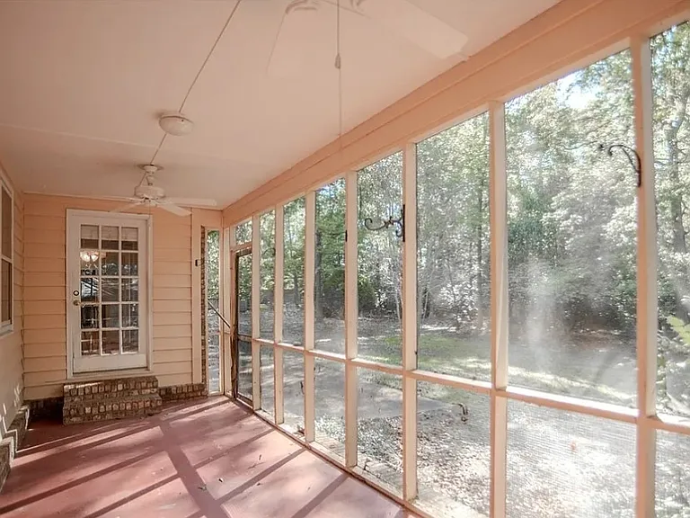 Large screen porch with new screens overlooking private back yard. Entryways into den and primary bedroom