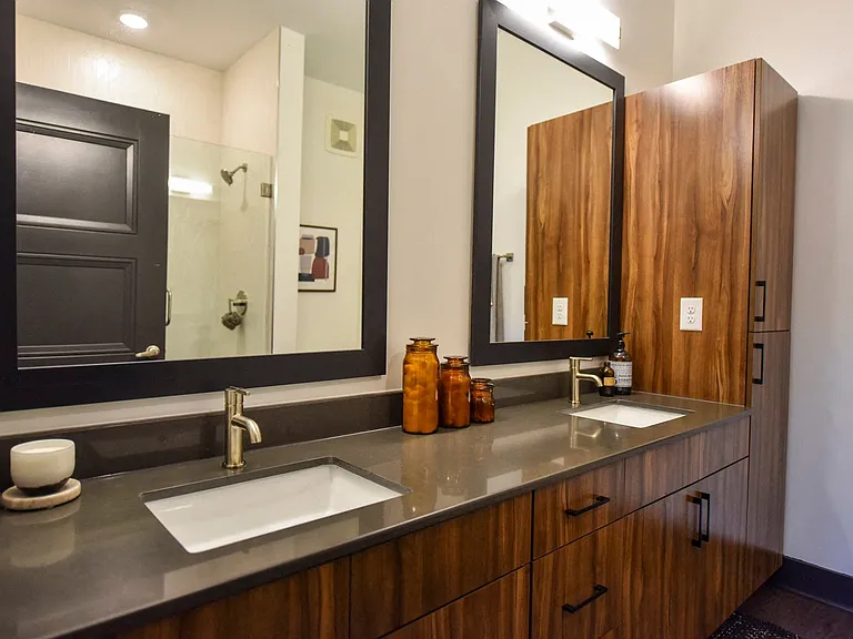 Spacious en-suite bath with dual vanities and custom-framed mirrors.