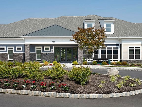 Inviting leasing center exterior with modern architecture and lush landscaped gardens.