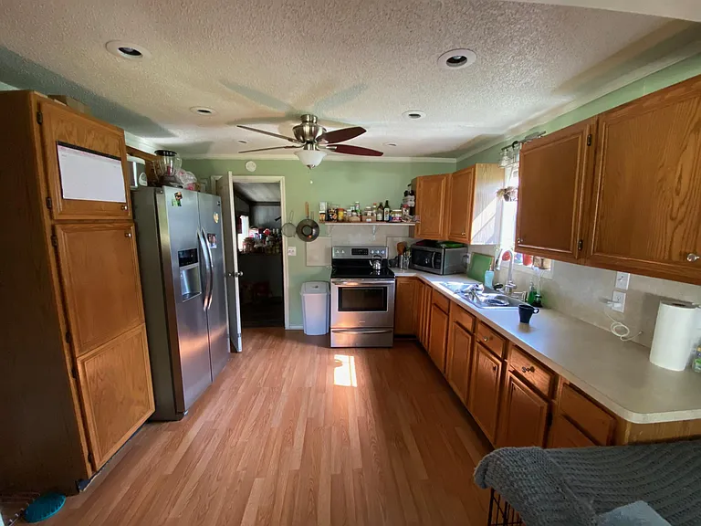 Kitchen with stainless fridge, oven, & microwave