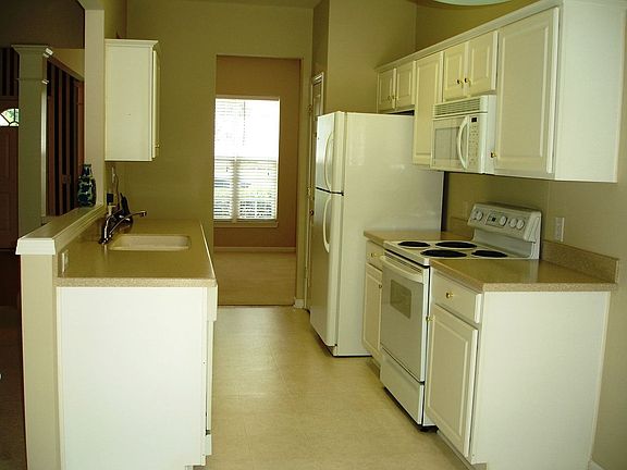 Modern Kitchen with Corian Countertops and Solid Wood Cabinets. Refrigerator C