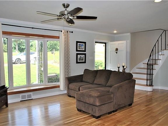 Stunning living room area offer huge bay window, gleaming hardwood floors, and more!