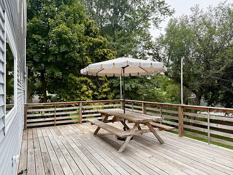 Large elevated patio with picnic table and umbrella