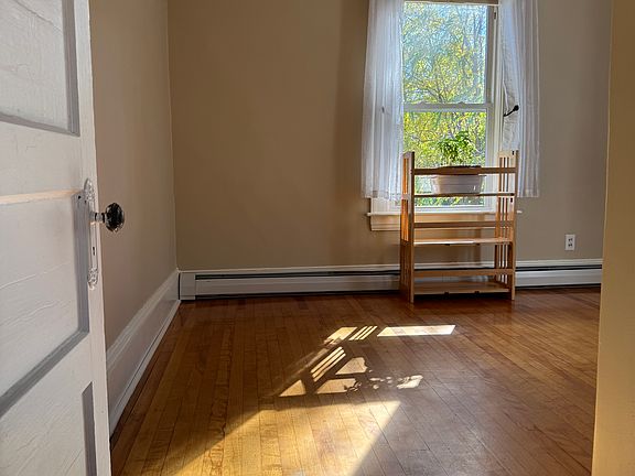 Newly-painted home office/bedroom. Windows face south and west. Original wood floor.