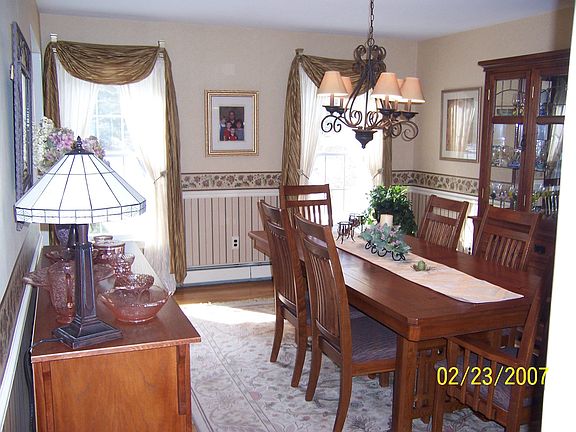 Bright Formal Dining Room with Chair Rail and Hardwood Flooring