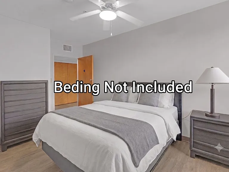 Spacious bedroom with a ceiling fan, wood-look flooring, and room for a full furniture set including dresser and nightstand.