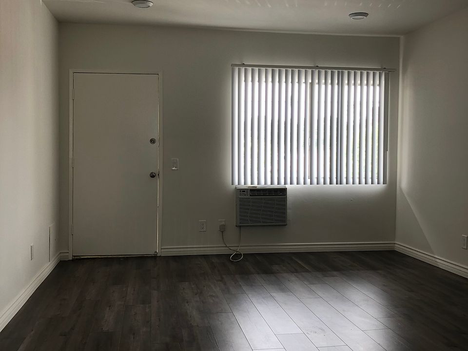 View of living room, facing west toward front door to apartment 6.