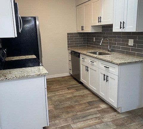 Updated kitchen with stainless appliances, white cabinets and granite countertops.