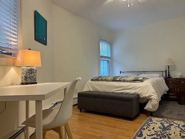 2nd bedroom boasts queen bed, desk, and white dresser