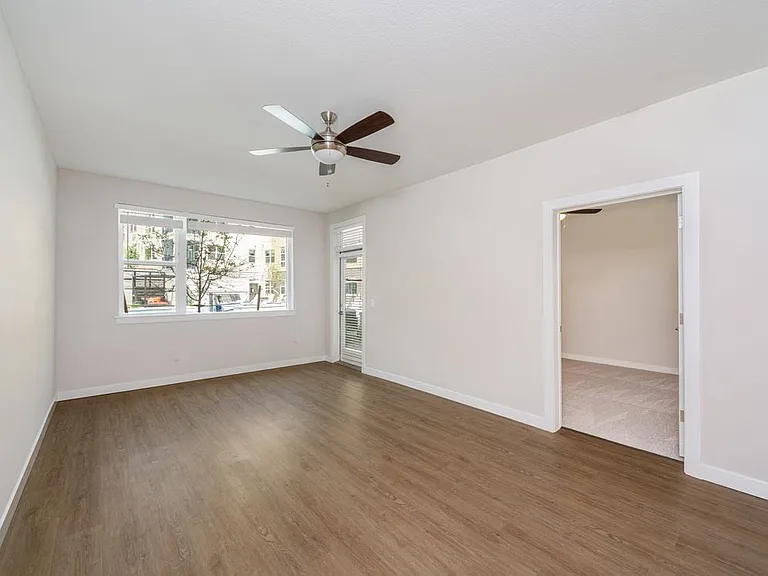 Finish Package I Living area with hard-surface vinyl plank flooring and ceiling fan