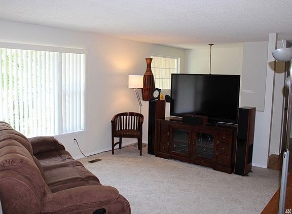 Light and airy living room with wood burning stove and easy access to the rear sundeck and yard.