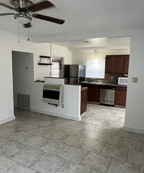 Open floor plan connects kitchen and living room with abundant natural light through large, updated windows including some window treatments-blinds and shades.