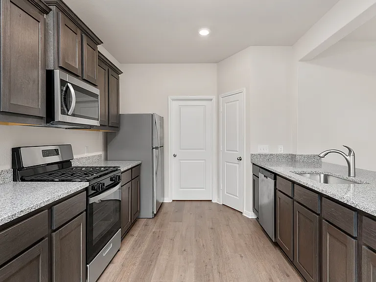 The kitchen has beautiful wood cabinetry and sprawling granite countertops.