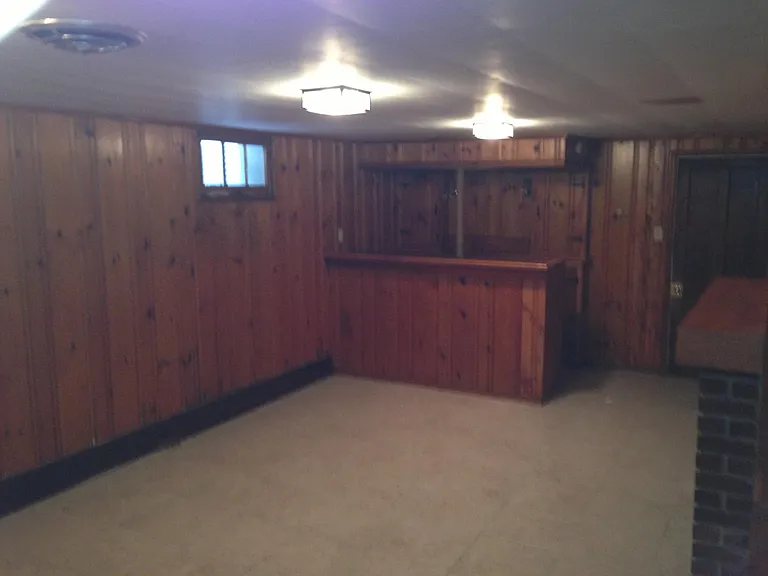 Basement with bar to entertain additional toilet in basement. Washer and dryer