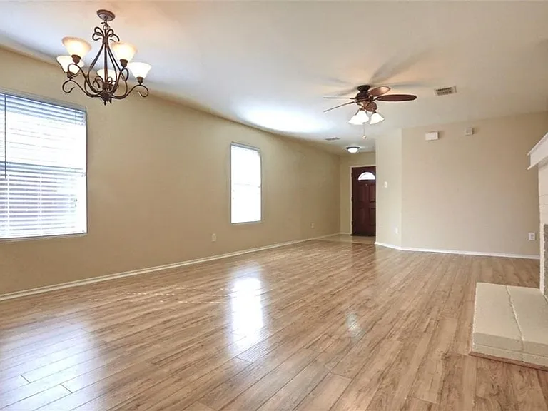 Spacious living room with light colored flooring.