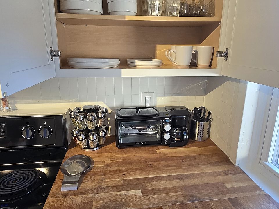 Fully stocked kitchen with dishes, glassware, cookware, utensils, and small appliances.