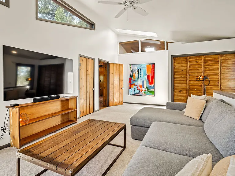 Alternate view of TV room, showing placement of laundry behind folding doors