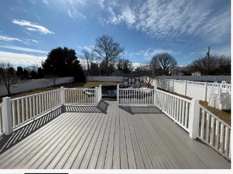 Large back porch overlooking fenced in yard