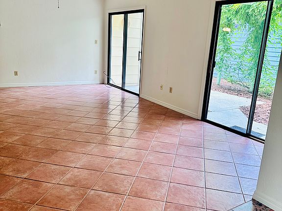 open living/dining room with cathedral ceilings and three sliding glass doors - light but private!