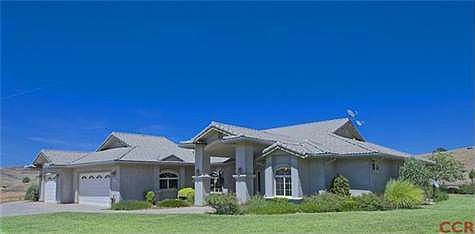 FRONT HOUSE SHOWING THE WRAP AROUND LAWN, 3 CAR GARAGE, COVERED ENTRY AND A PEEK OF THE VIEW!