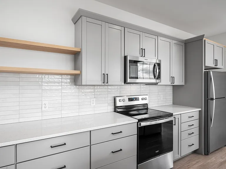 Modern kitchen with sleek gray cabinets, stainless steel appliances, and elegant open shelving. Modern kitchen with sleek gray cabinets, stainless steel appliances, and elegant open shelving.