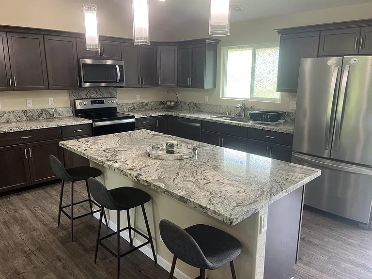 Spacious chefs kitchen w newer appliances, granite countertops and a large island, plenty of storage