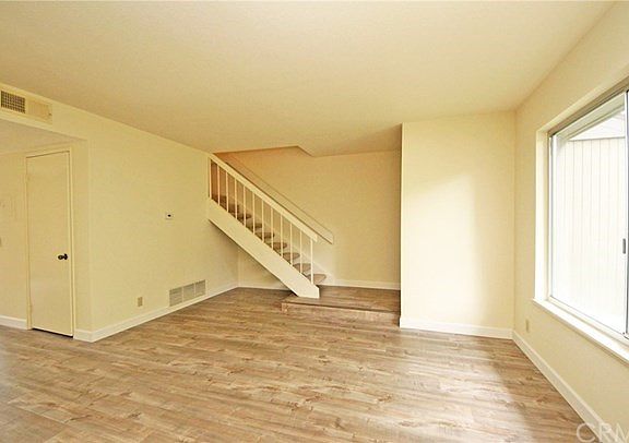 Open staircase leads to 3 bedrooms and 2 bathrooms