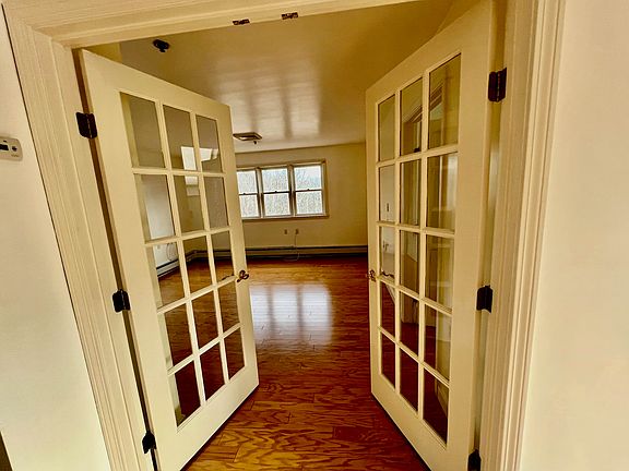 View into second bedroom through double french doors, taken from dining room area.