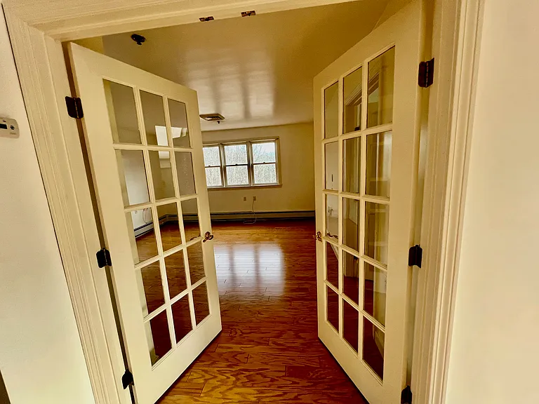 Second bedroom (5'10" x 15' 2") seen thru double french doors, taken from dining room
